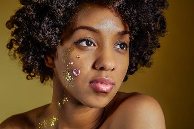 Woman with natural makeup and decorative face art showcasing professional makeup services.